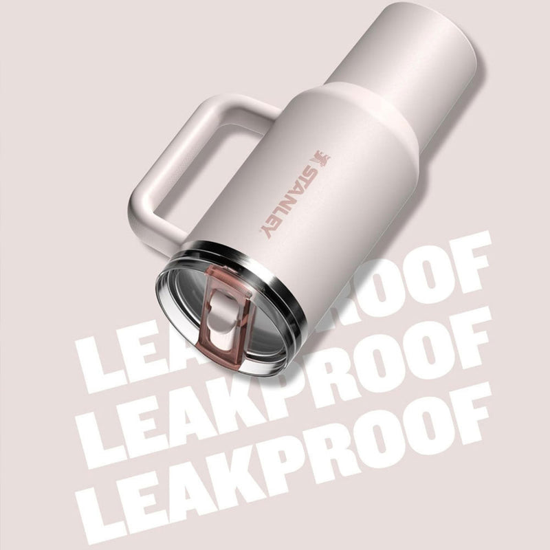 Stainless steel tumbler with 'Stanley' branding on a light pink background with 'LEAKPROOF' text.